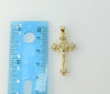 Close-up of a gold-plated small cross pendant with ornate details.
Close-up of a delicate gold-plated crucifix pendant d