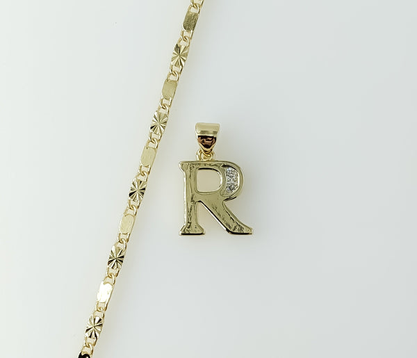 Dainty gold plated letter "R" star pendant on a chain necklace.