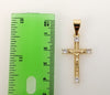 A delicate gold plated cross pendant with intricate design details.
A small gold plated cross pendant with ornate twist
