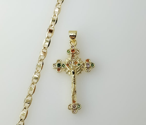 A gold-plated flat chain necklace with a small Jesus crucifix pendant and anchor charm.